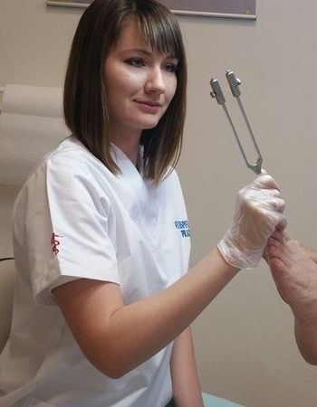 Fußpflegerin mit Instrument bei der Arbeit